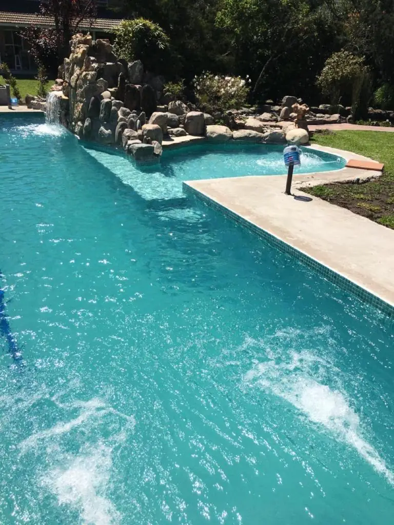 Pileta de 12x3 con cascada y jacuzzi construida por Piletas Norte en Barrio La Delfina